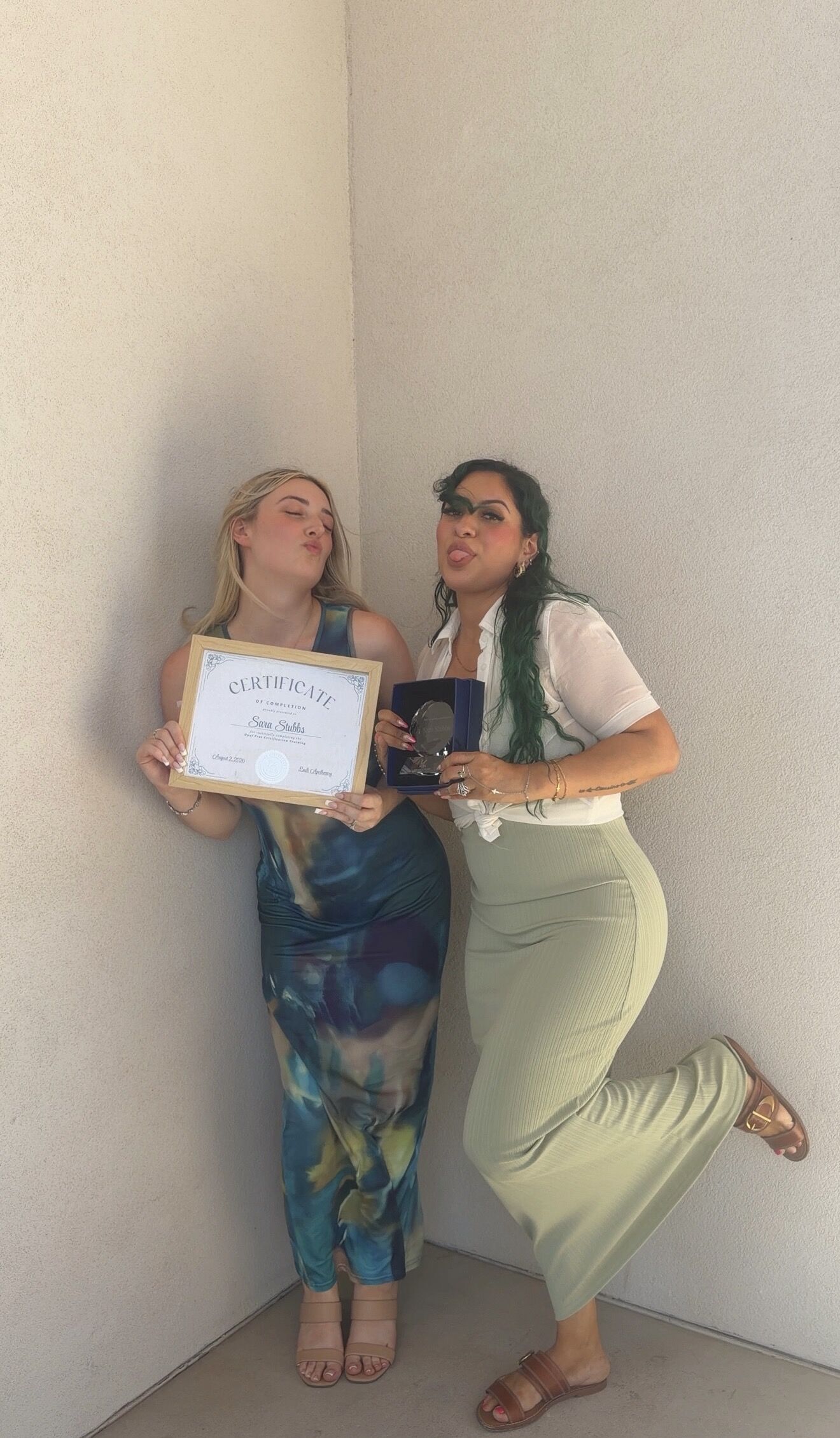 Cortney and a graduate posing with a certificate